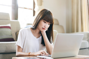 Asian teenager woman work and study online via internet at home.