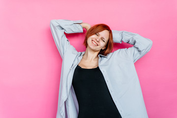 Beautiful young woman in the blue shirt and black t-shirt over pink background