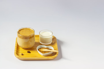 Whipped dalgona coffee. Trend Korean drink made from instant coffee, sugar and milk in a glass cup on a white background.