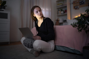 Worried young girl with laptop sitting and smiling, online dating concept.