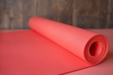 Pink yoga mat with a wooden background.