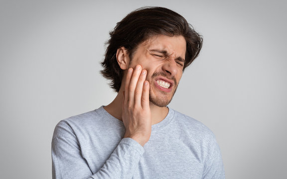 Man suffering from terrible strong teeth pain