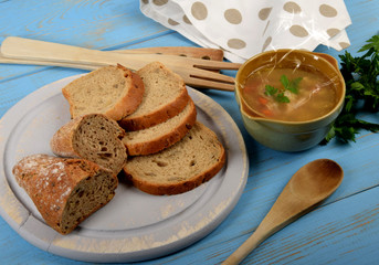 tripe soup in a small brown bowl next to dry bread