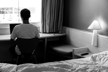 Man doing home office from a hotel room. Black And White