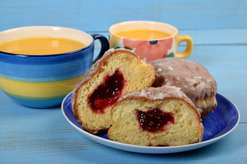 donuts stuffed with raspberry jam next to orange juice