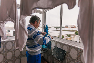 Senior man hanging clothes.