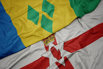 waving colorful flag of northern ireland and national flag of saint vincent and the grenadines.