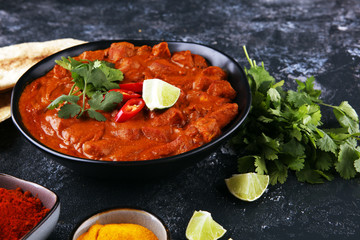 Chicken tikka masala spicy curry meat food in pot with rice and naan bread. indian food on table