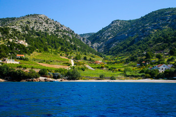 Cultivated slopes on the island of Brac in Croatia in the Adriatic Sea - Green fields surrounded by rugged peaks seen from a boat