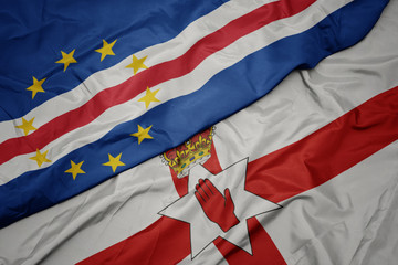 waving colorful flag of northern ireland and national flag of cape verde.