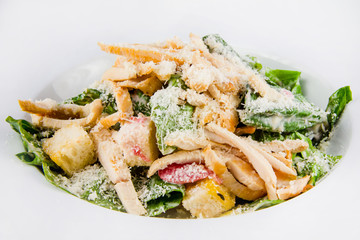 Plate with fresh caesar salad. Closeup on white background