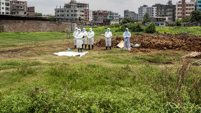 Members of Al-Markazul Islami Bangladesh praying for a Person who died by Coronavirus to the grave for funeral at Khilgaon Taltola Graveyard in Bangladesh on Friday morning April 24,2020.