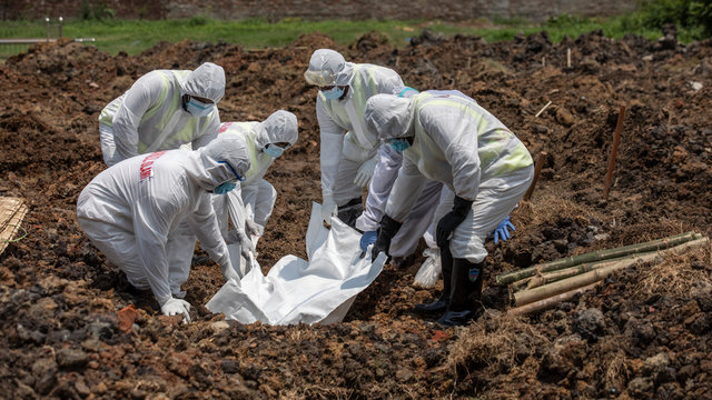 Members of Al-Markazul Islami Bangladesh carry a Person who died by Coronavirus to the grave for funeral at Khilgaon Taltola Graveyard in Bangladesh on Friday morning April 24,2020.