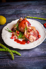 Duck leg with pear in sauce on deep blue wooden background lemon 