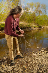 Man exploring river water by magnet on rope