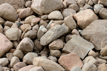 a pile or pile of rocks on the beach. A lot of big stones.