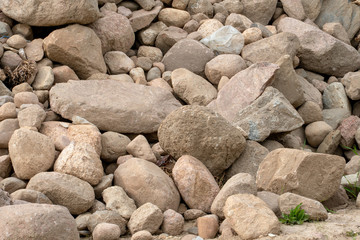 a pile or pile of rocks on the beach. A lot of big stones.