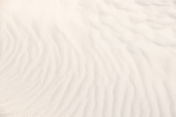 Background with waves sand. Light patterns on the sand of dune. Sand texture. Top view. Background, sand, light, beige, wave, reflect, shadow, summer.