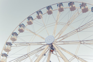 A part of ferris and blue sky. Beatiful background with ferris. Blue, light, white, sky, ferris wheel. Ferris wheel and piece sunlight. Vintage style.