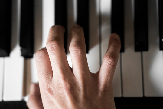 Detalle de la mano de una mujer tocando el piano.