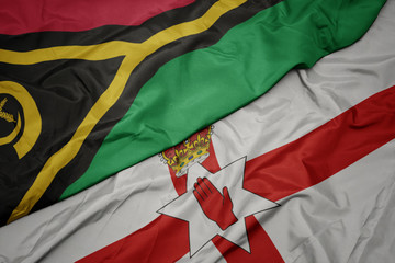 waving colorful flag of northern ireland and national flag of Vanuatu .