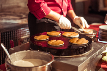 Cook cooks pancakes on the stove
