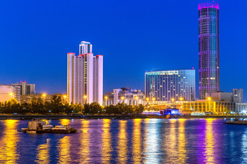 Naklejka premium Night view of the skyscrapers of the city of Yekaterinburg. Russia. Reflection in the river