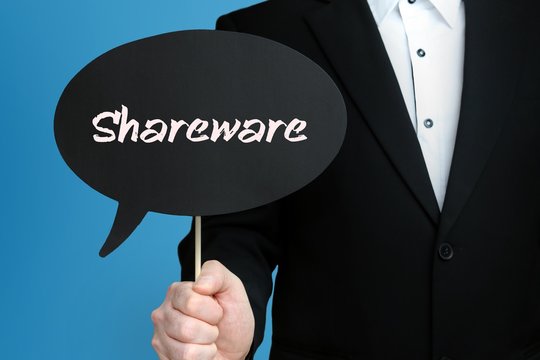 Shareware. Businessman in suit holds speech bubble at camera. The term Shareware is in the sign. Symbol for business, finance, statistics, analysis, economy
