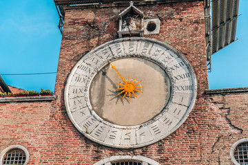 A large brick tower with a clock on the side of a building