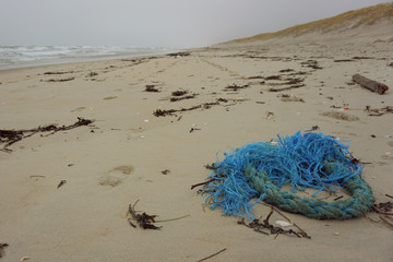 Ropes from the ship on a sand after sea storm. Garbage in the nature. Environmental pollution. Ecological problem.