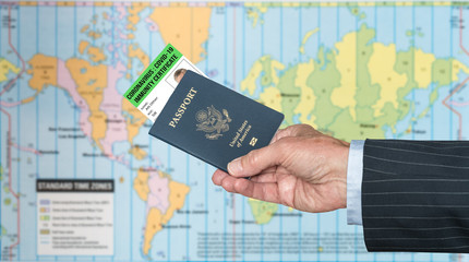 Senior man arm in suit and hand holding a USA passport with a coronavirus immunity certificate against global map