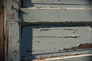 peeling paint on old wooden door with textured grey paint chipping off