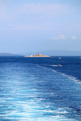 Boats and lighthouse on a small island near town Hvar, on island Hvar, Croatia. 