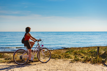 Fototapeta premium Woman ride bicycle on beach, active lifestyle.