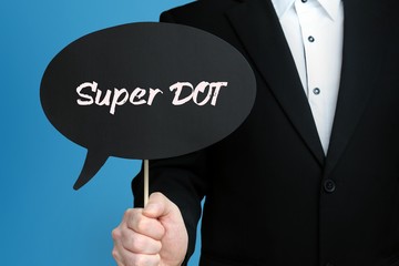 Super DOT. Businessman in suit holds speech bubble at camera. The term Super DOT is in the sign. Symbol for business, finance, statistics, analysis, economy