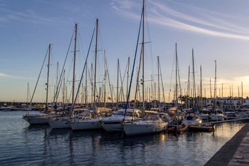 Obraz na płótnie Canvas Yachts in puerto de mogan harbour baithed in warm evening light