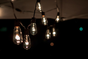 String of lightbulbs hanging from a tent at night