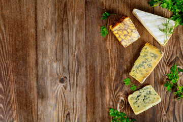 Different types of cheese on wooden background.