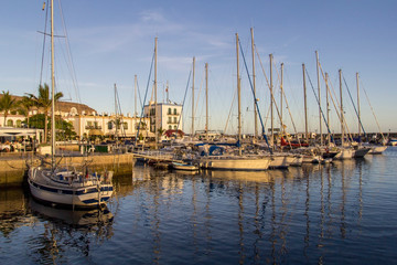 Fototapeta na wymiar boats in a beautiful golden sunlit harbour in puerto de mogan, gran canaria spain