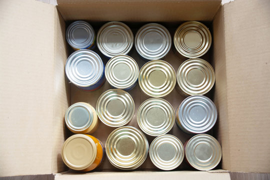Silver food steel cans in cardboard box closeup food delivery