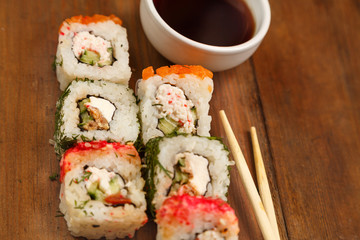Set of rolls with dill and salmon with soy sauce and chopsticks.