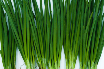 Green onion stems isolated on a white surface.  Vegetable background.