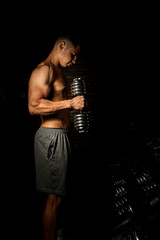 Fototapeta na wymiar Homem com corpo definido e musculoso, treinando para competições de musculação