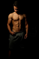 Fototapeta na wymiar Homem com corpo definido e musculoso, treinando para competições de musculação