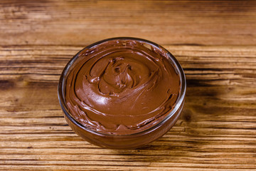 Glass bowl with chocolate spread on a wooden table