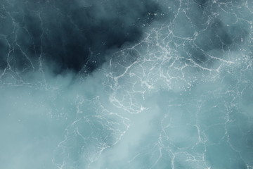 The propellers of the ship made the sea water turquoise and the whirlpool gives a marble look.