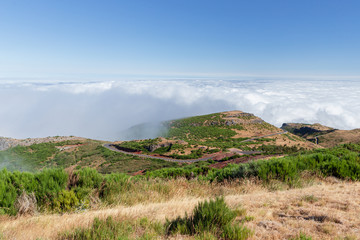 The scenic asphalt highway curving in the clouds in the beautiful mountain valley of Pico Arieiro on Madeira island, Portugal