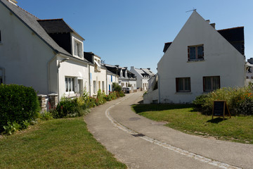 Fototapeta na wymiar Une route entre des maisons neuves dans un village de l'ile de Houat en Bretagne USAGE UNIQUEMENT EDITORIAL