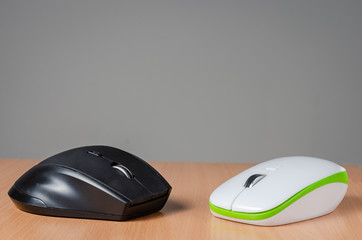 Close view of two wireless- bluetooth  pc mouse devices   on wooden  background.