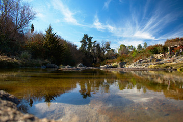 Fototapeta na wymiar Paisaje de arroyo reflejando el cielo y las piedras.